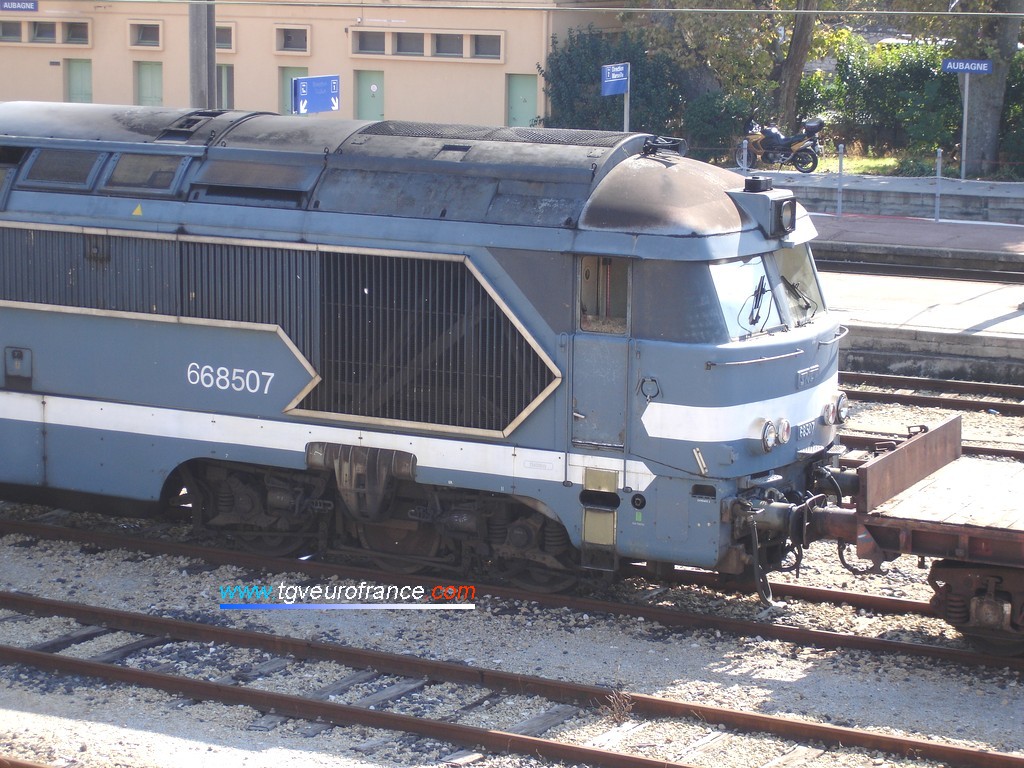 Une locomotive Diesel-électrique (A1A A1A  668507 de l'Infrastructure SNCF) à moteur AGO en livrée Arzens en tête d'un train de travaux à Aubagne