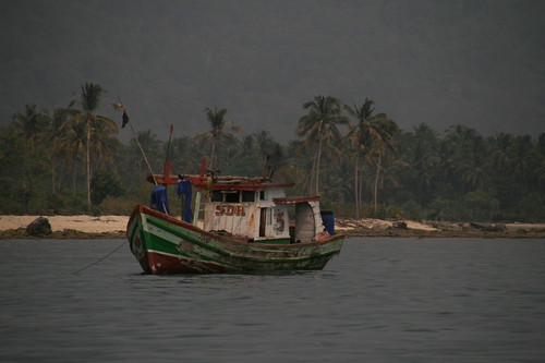 Fischerboot vor Dschungelkulisse