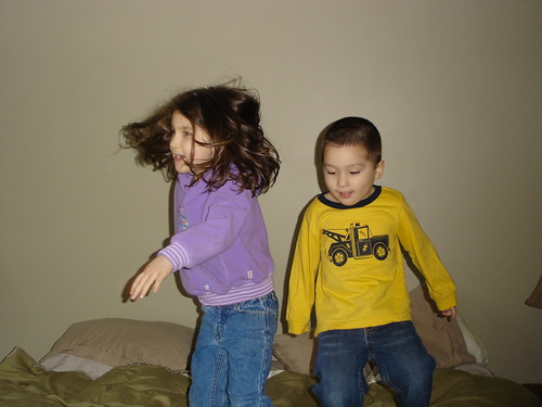 Two little monkeys jumping on the bed