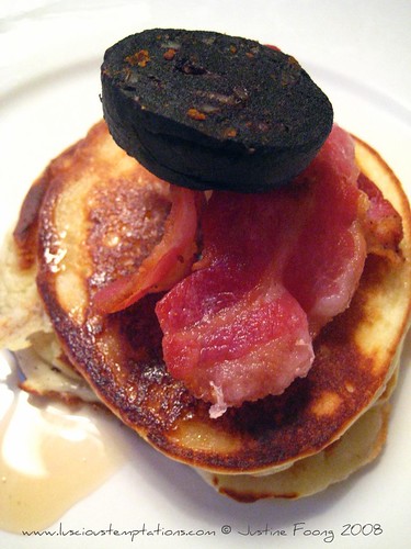 Fluffy American Pancakes with Crispy Bacon and Maple Syrup. Topped with a Slice of Black Pudding