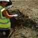 Ruth excavating a small pit cut [1421] in a section created by a foundation trench