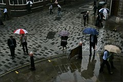 People walk in the rain in central London's financial center. 