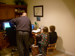 Powell, Thomas, Pie, and Dad Gathered Around the Computer
