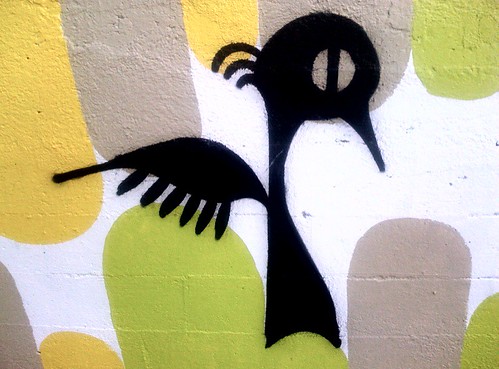 graffiti -- cartoon blackbird standing upright, wings pushed behind 