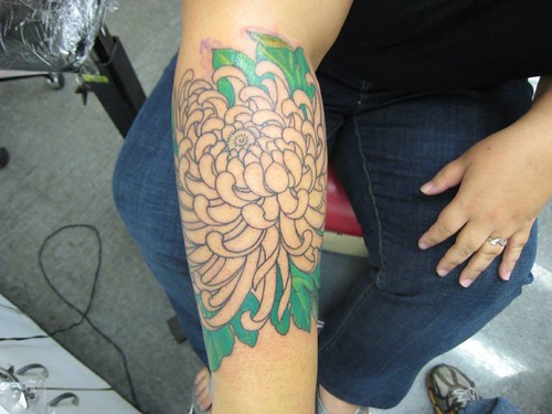  outline of chrysanthemum tattoo and green leaves filled in so far 