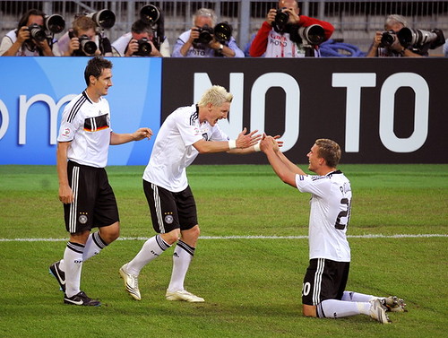 Lukas Podolski congratulates midfielder teammate Bastian Schweinsteiger next to forward Miroslav Klose