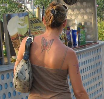 Like Mother, with designer purse and back and arm tats