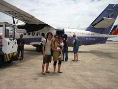a large-foreheaded family in front of a small plane