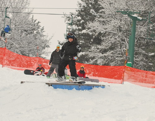 A young snowboarder rides a rail in the terrain park at Afton Alps, 
