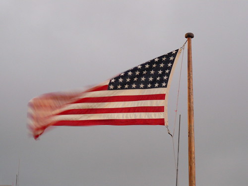 At the stern end of the flight deck, a remembered flag flaps in the breeze