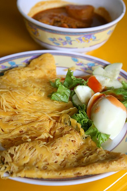 Roti Jala with boiled egg, salad and curry chicken in bowl