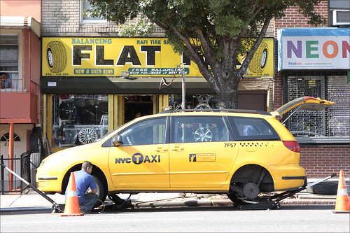 A NYC cab is repaired for a flat tire
