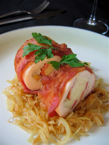 Chicken breast wrapped apple on a bed of caramelized onion