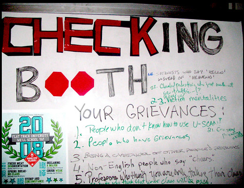 "Checking Booth" grievance list on dry erase board