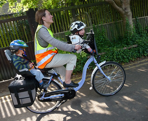 Mum with two kids on one bike by Dee Railer.