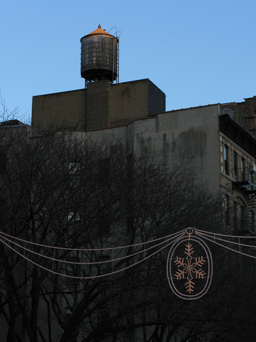 Christmas decoration lights and a water tower at sunset, Manhattan, NYC