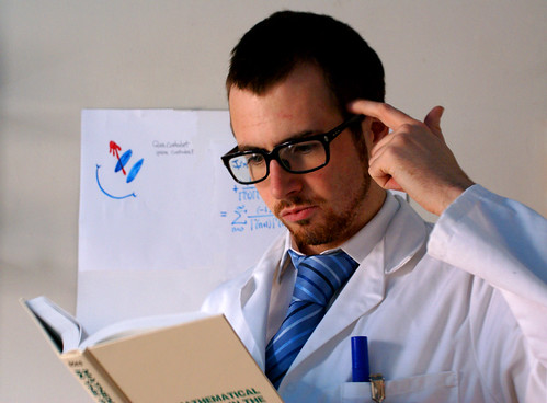 Photo of a scientist puzzling over a math book