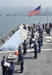 US sailors loading humanitarian cargo on the deck of guided-missile destroyer USS McFaul