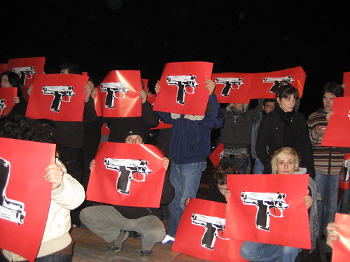 Protesters holding photoshopped image of gun to protest police shooting