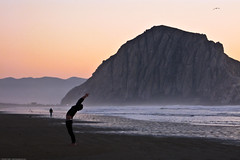 Man performs mystical stretching exercises on Morro Strand (by mikebaird)