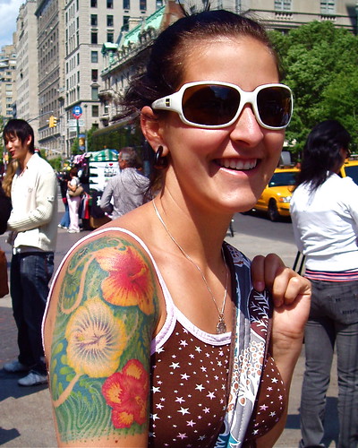 Her shoulder and upper arm are covered with hibiscus blossoms