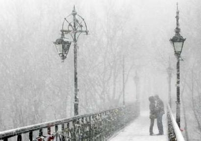 A couple kisses on Kiev's Bridge of Lovers on Valentine's Day
