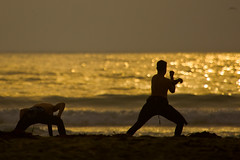 Two Surfers do Pre-stretches on Morro Strand State Beach prior to a sunset surf session - Not Tai Chi