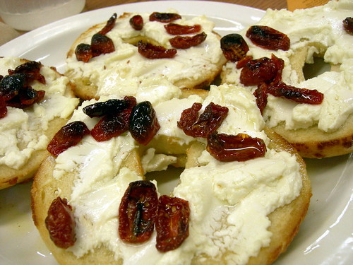Cheese bagel with goat cheese and dried tomatos in olive oil