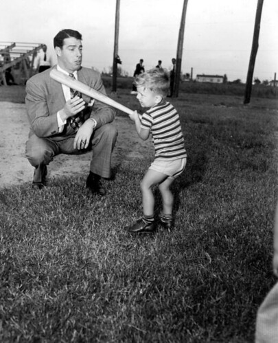 Joe DiMaggio showing three year old Larry Valencourt how to hold a bat: West Palm Beach, Florida