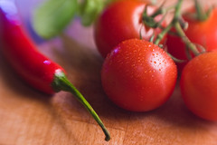 Ein Bild das eine Tomate und eine Peperonie in Nahaufnahme zeigt