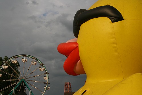 ferris wheel in the background, giant duck in the foreground