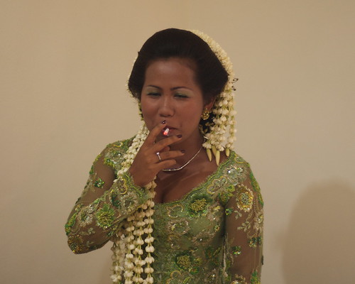 Traditional Javanese Bride with cigarette There were lots of flower petals 