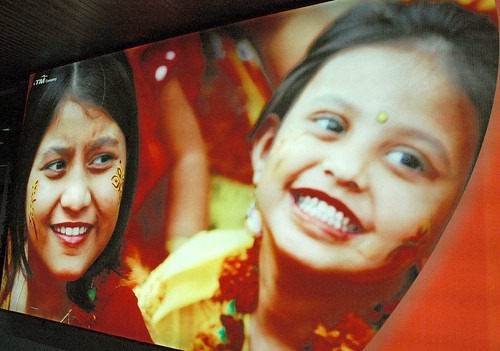 Henna painted on two smiling girls, red, photo advertisment promoting tourism, Dhaka, Bangladesh by Wonderlane