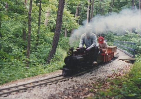 7 and 1/2 " guage steam train rounding a curve in the woods. The Hesston Steam Museum. Hesston Indiana USA. June 1994.