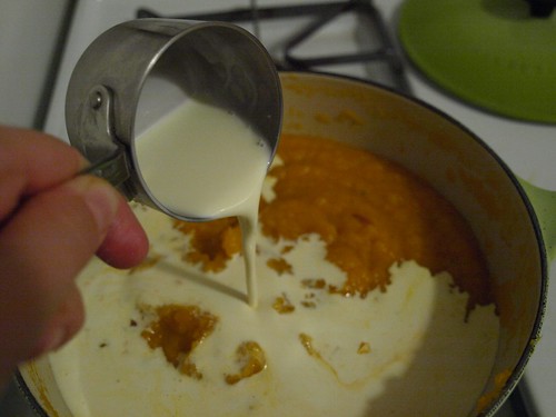 adding cream to pumpkin soup