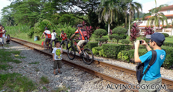 Spotted cyclists riding along the railway track