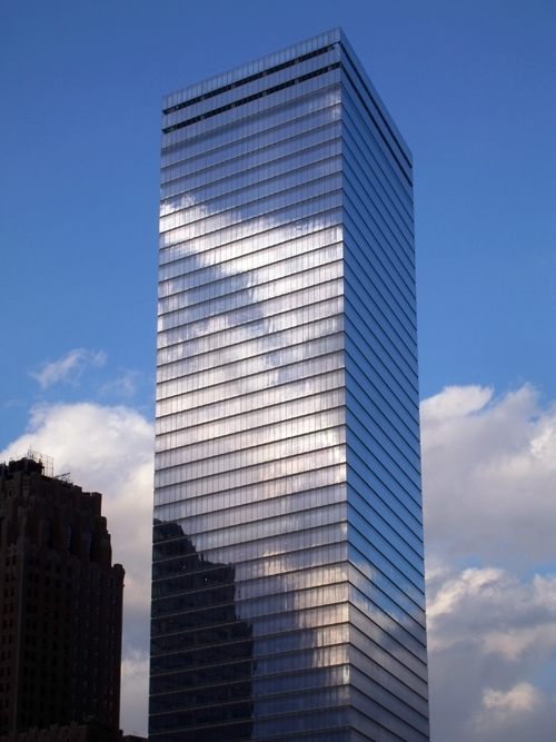 a building in lower Manhattan reflects clouds, NYC