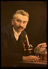 Louis Lumiere with microscope and test tubes