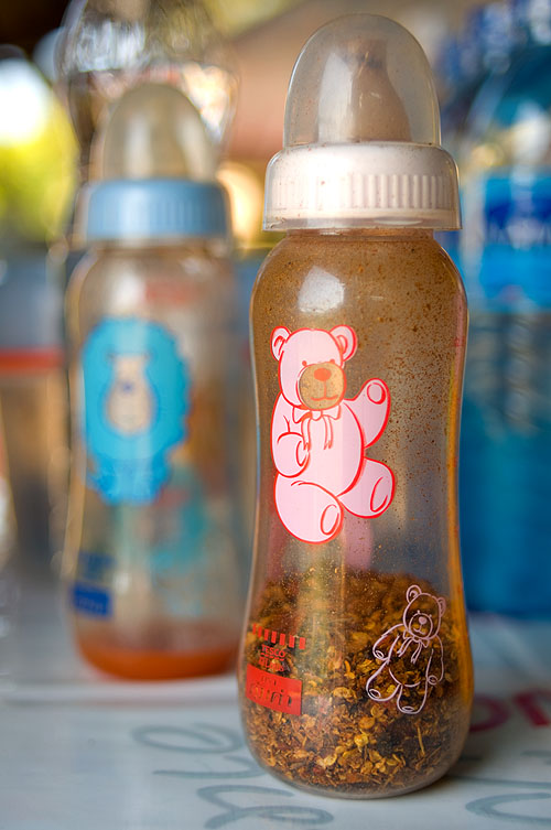Baby bottles filled with chiii flakes and chili sauce. They start them off early in Nan