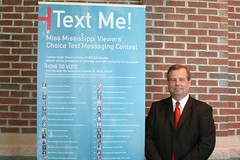 Cellular South rep next to Text Messaging Contest sign 6-21 by Cellular South Miss Mississippi 4