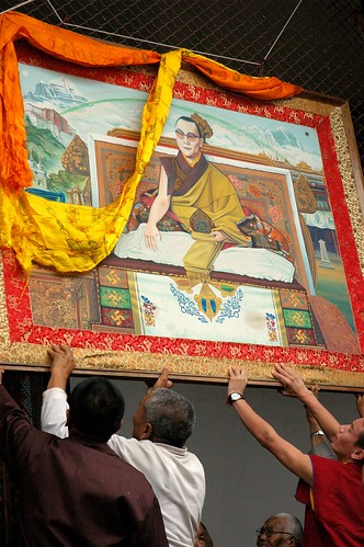 Hanging a portrait of His Holiness the Dalai Lama at Tharlam Monastery, Boudha, Kathmandu, Nepal by Wonderlane
