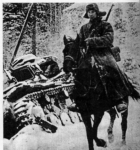 Os Panzer foram derrotados. Um soldado de cavalaria, russo, passa junto aos restos de um tanque alemão coberto de neve. A foto constitui um símbolo do desastre alemão.