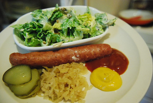 Farmer sausage with pickles, sauerkraut, mustard, ketchup and salad