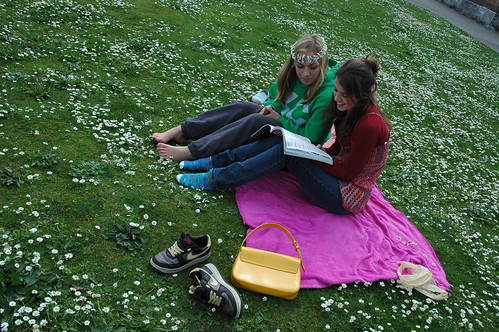 Girls reading a book in a field of daisies, one wears a daisey chain crown, Seattle, Washington, USA by Wonderlane