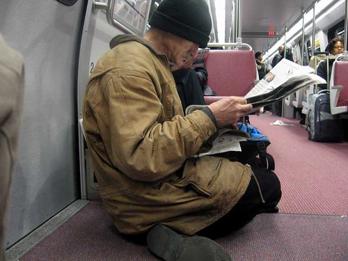 Man reading newspaper on Metro