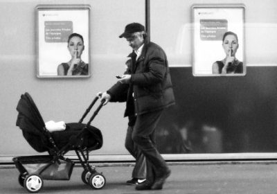 Man walks baby while SMSing
