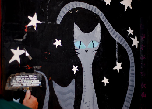 graffiti of a cat, tall and long, tail waved up over her head