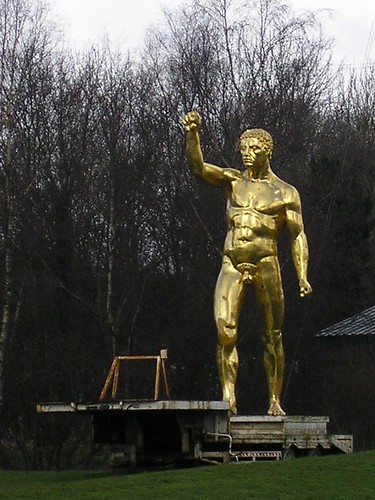 statue of golden man on a low loader