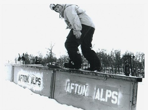 A snowboarder on a rail in the terrain park at Afton Alps, 