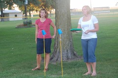Brooke and Gwen play the cup-stick-frisbee game.